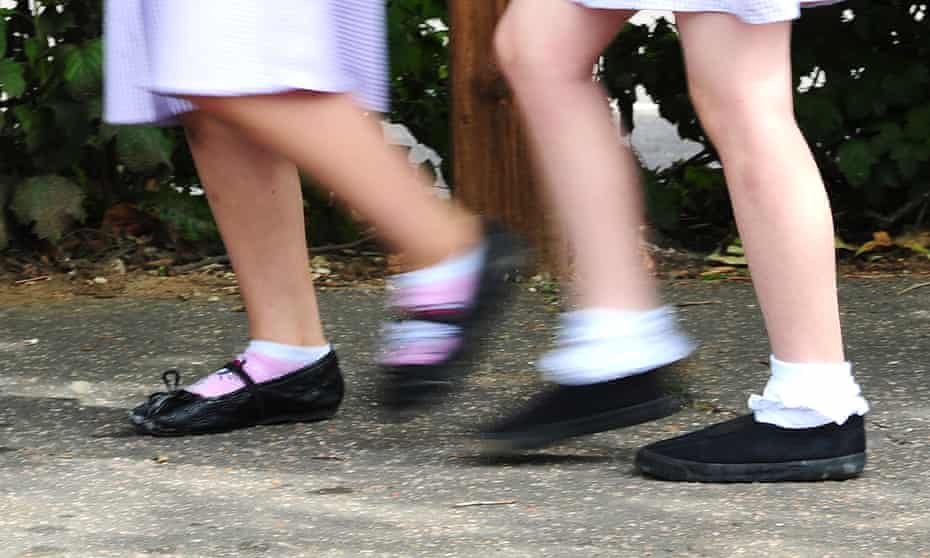 two girls walking to school, only legs and feet visible
