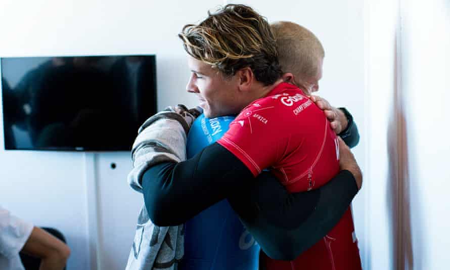 Australian surfer Mick Fanning, in blue, hugs compatriot and finals rival Julian Wilson after the attack.