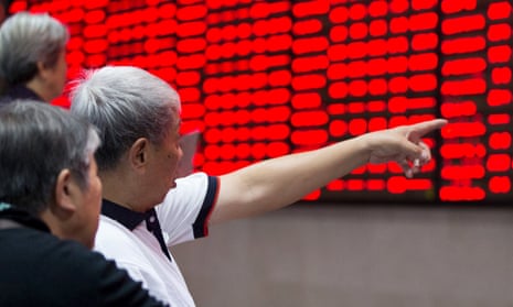 A Chinese investor points at a board of share prices