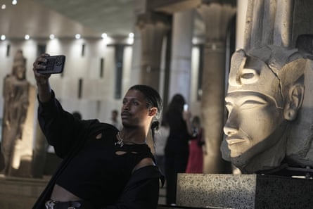 A tourist takes a selfie in front of a huge stone head