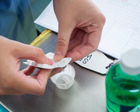 Un miembro del personal del NHS saca un medicamento de un blíster.
