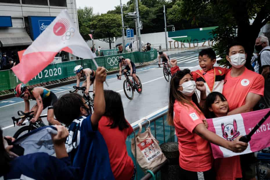 People cheer on athletes during the women’s individual triathlon competition at the Tokyo 2020 Olympic Games at the Odaiba Marine Park in Tokyo on July 27