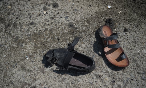 A sandal and a shoe belonging to bombing victims are seen on a road at the site of a suicide bombing attack in Kabul in March 2018