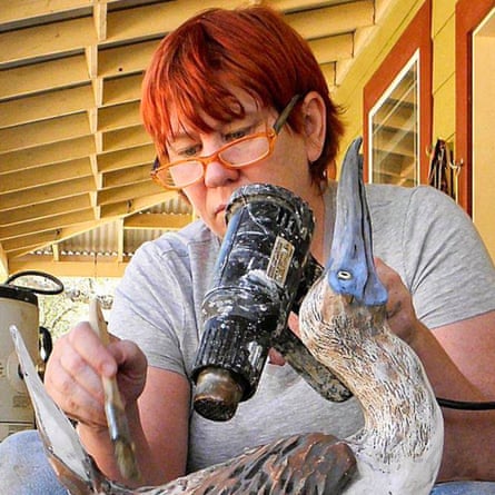 a woman paints a model bird