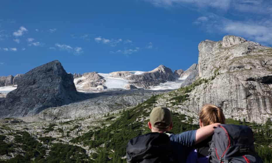Hikers looking at the Marmolada glacier from the Fedaia dam V1