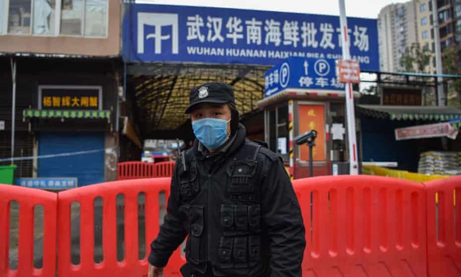 A police officer guards Huanan seafood market in Wuhan in January 2020 after the outbreak of coronavirus in the Chinese city.
