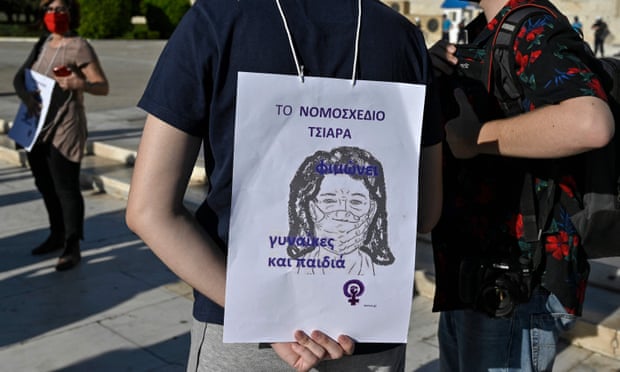 An activist holds a placard reading ‘the law forces women into silence’ at a protest in May over a controversial law giving divorced fathers equal time with their children. Rights groups say it ignores victims of domestic violence and puts women and children at risk.