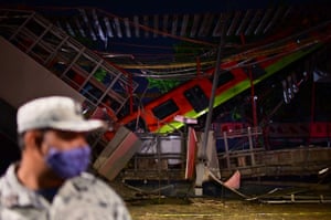 A damaged metro car. A crane was used to hold up one subway car left dangling on the collapsed section so that emergency workers could enter to check if anyone was still trapped