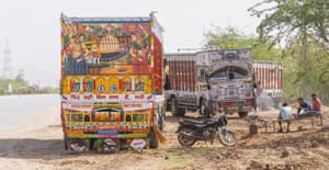 The back of a brightly designed truck with pictures of women and fields