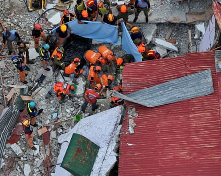 A drone shows rescue workers conducting a rescue operation at a collapsed building in Bogo.
