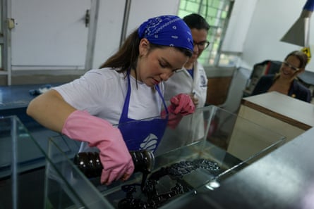 Selene Estrach from NGO Proyecto Sirena puts crude oil into a tank for an experiment, at Zulia University in Maracaibo.