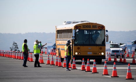 A school bus transporting teachers and support staff arrives at a mass vaccination site in a parking lot at Hollywood Park in Inglewood, California. 