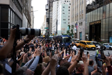 Crowds of arms holding up cellphones toward city street.
