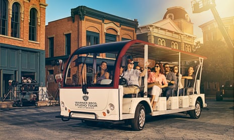 A publicity image of guests in a tour cart on the lot at the Warner Bros studio tour in Hollywood, Los Angeles, US.