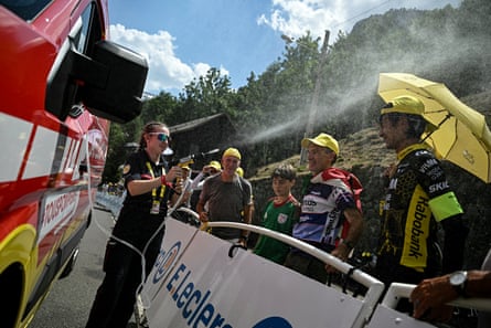 A female firefighter sprays water at spectators