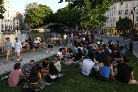 People sit on the banks of the Canal Saint-Martin in Paris.