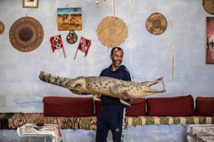 Mamdouh Hassan carries a mummified crocodile, Franco, which recently died. A dead crocodile is filled with straw or sawdust and can take from a few days to a month to mummify