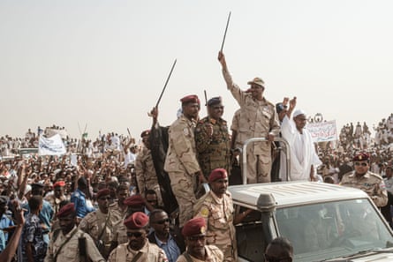 Gen Mohamed Hamdan Dagalo (Hemedti) salutes the crowd from the back of a truck at a military rally