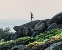 Man standing high up on rocks at the popular destination of The Roaches in North Staffordshire nr the market town of Leek ,England UK.R4BNRJ Man standing high up on rocks at the popular destination of The Roaches in North Staffordshire nr the market town of Leek ,England UK.