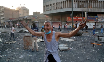 A man gestures at fellow demonstrators to join the protest during clashes with Iraqi security forces at Khilani Square in Baghdad.