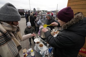 People fleeing the conflict from neighbouring Ukraine receive hot beverages at the border crossing in Medyka, south-east Poland