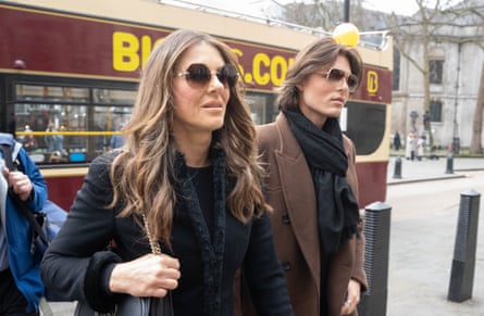Elizabeth Hurley and her son, Damian, both wearing sunglasses, on the street about to enter court