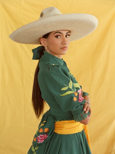 A woman poses against a yellow background