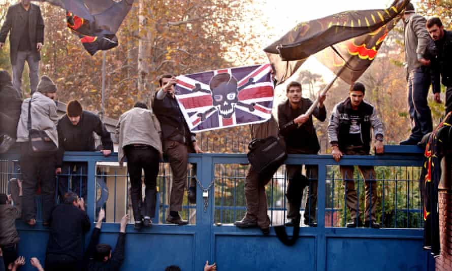 Iranian students stand on the gates of the British embassy in Tehran in November 2011.