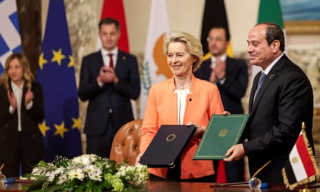 Ursula von der Leyen and Abdel Fatah al-Sisi hold up  signed declarations, watched by EU leaders in the background
