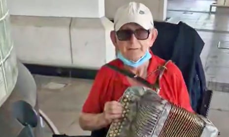 Thomas O'Halloran, 87, on his mobility scooter playing the accordian outside a Tesco in Perivale, west London