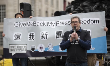 Benedict Rogers, the head of Hong Kong Watch, with microphone and banner behind him