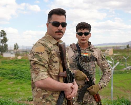 People in military fatigues holding weapons