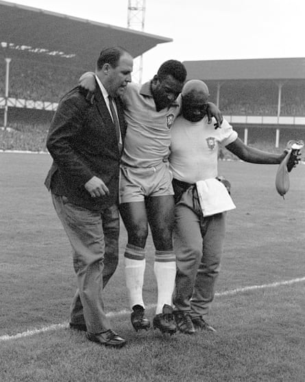 Pelé is helped from the pitch by Brazil’s doctor, Hilton Gosling, and the trainer Americo during the 3-1 defeat by Portugal at the 1966 World Cup
