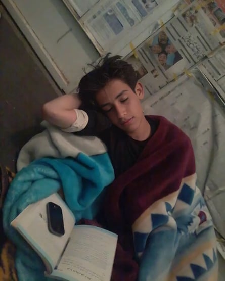 A young boy is shown sleeping with a book in his lap