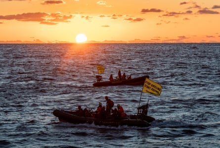 Greenpeace activists at sunrise prepare to board a Shell oil platform.