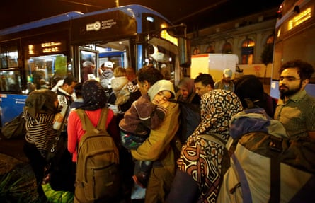 Migrants enter a bus, which is due to leave Keleti train station in Budapest on route for Austria