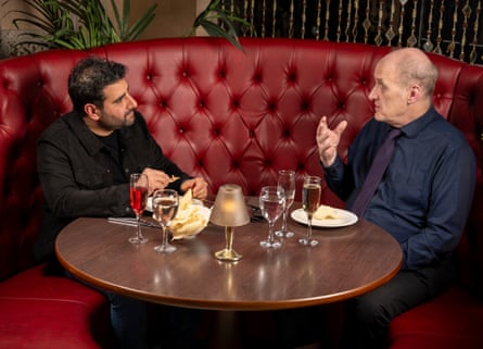 Two men facing each other at a restaurant table