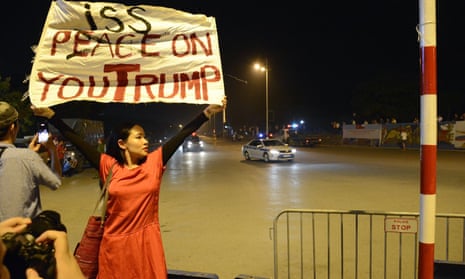 Vietnam dissident musician Mai Khoi holds up a banner reading ‘Piss on you Trump’ in Hanoi as the US president’s motorcade passes. 
