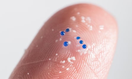 Closeup of plastic microbeads on the tip of a finger