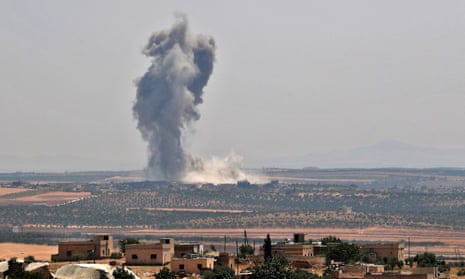 Smoke billows above buildings during a reported air strike by pro-regime forces on Khan Sheikhun on Monday.
