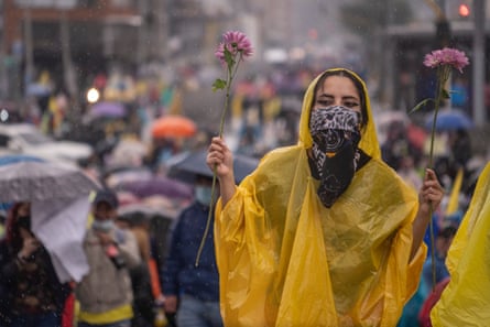 A demonstrator holds a flower as she marches in the rain in Bogotá, Colombia, on 5 May.
