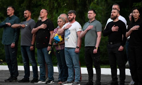 The commanders and their relatives sing Ukraine’s national anthem.