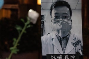 Flores com um pôster do denunciante Dr. Li Wenliang