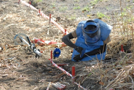 A deminer manually removes a mine.