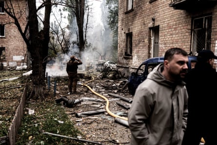 Firefighters working at the scene of a Russian drone strike in a residential area in Kyiv on Thursday.