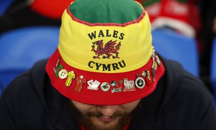 A Wales fan wearing a bucket hat with pin badges.