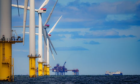 RWE's Gwynt y Môr, the world's second-largest offshore windfarm, off the coast of north Wales: view of a line of turbines and engineering platforms in the sea against a blue sky with soft clouds