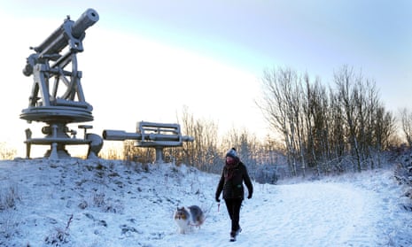 A woman walks her dog through overnight snow near the Terris Novalis sculpture in Consett, County Durham. 
