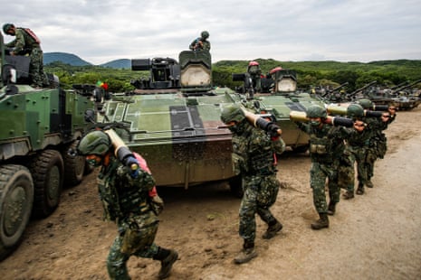 Taiwanese soldiers carrying artillery to tanks during a live-fire drill