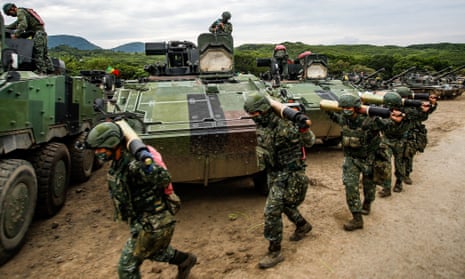 Taiwanese soldiers carrying artillery to tanks during a live-fire drill.